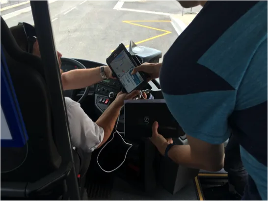 Dans le bus, à côté du conducteur, pendant qu'il utilise l'app